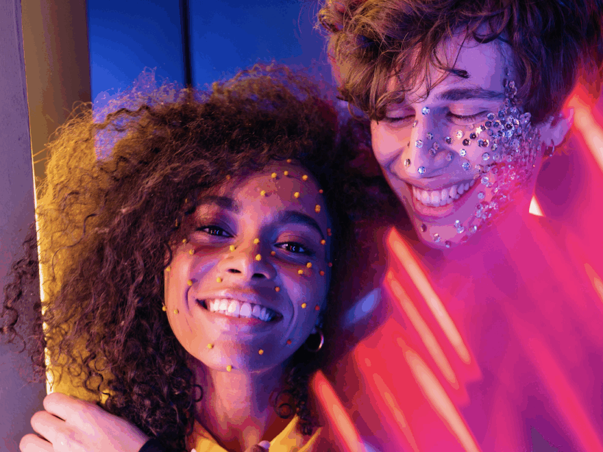 two people glitter face make-up smiling hug