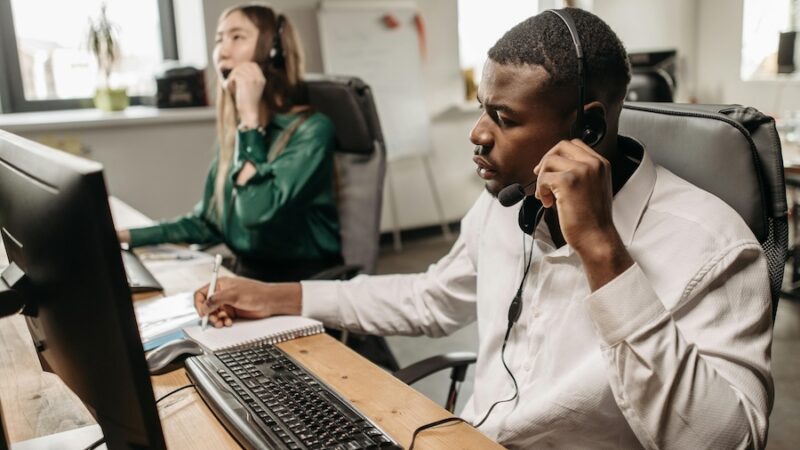 two people headset computer call centre