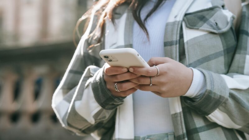 person on mobile phone two hands typing