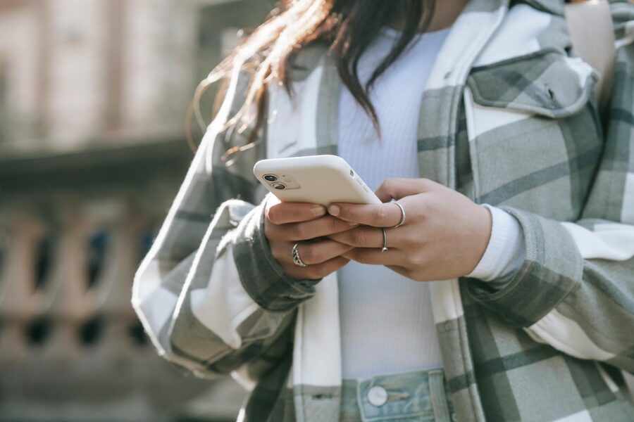 person on mobile phone two hands typing