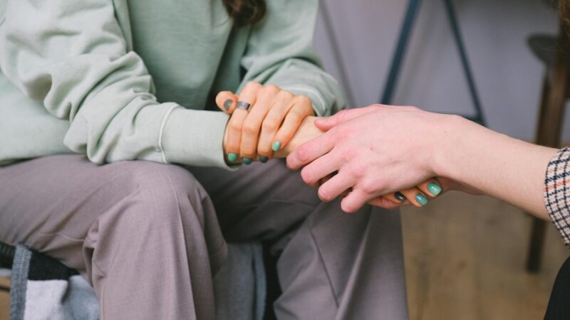 person holding hands green nail polish