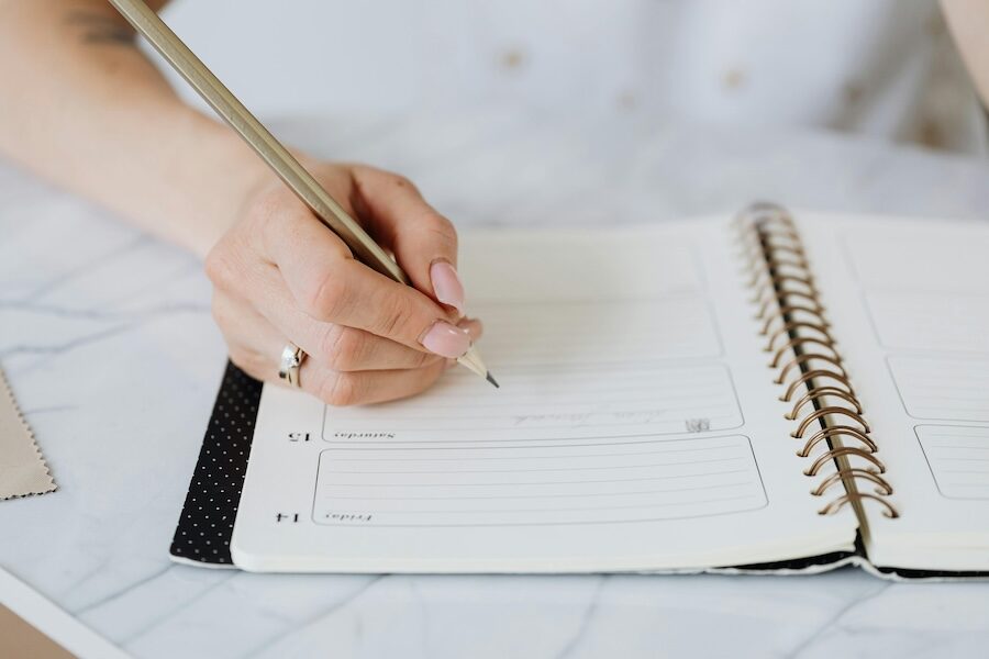 person writing in diary calendar