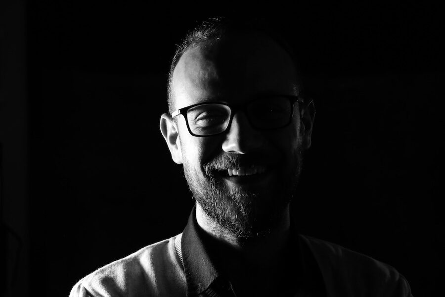 smiling person wearing glasses black and white