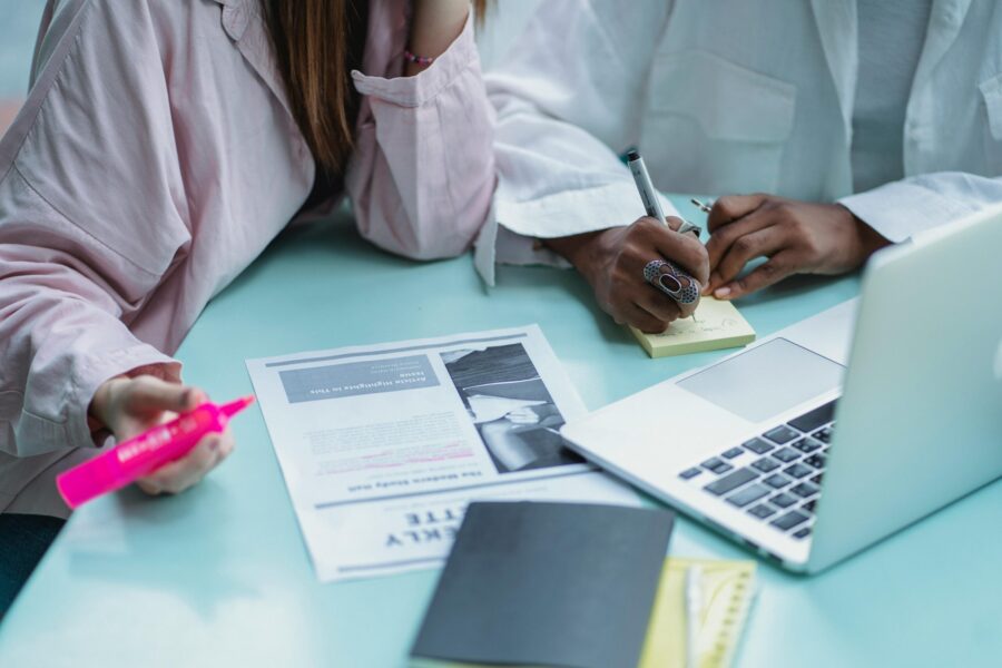 two people taking notes post-it pink highlighter