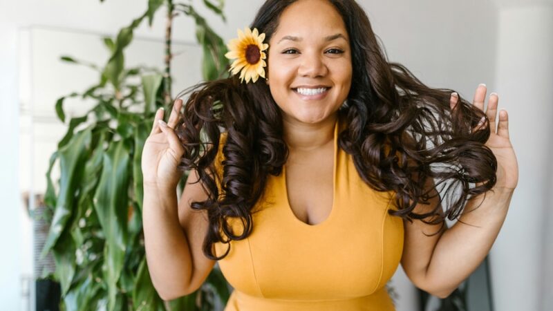 smiling person with sunflower in hair