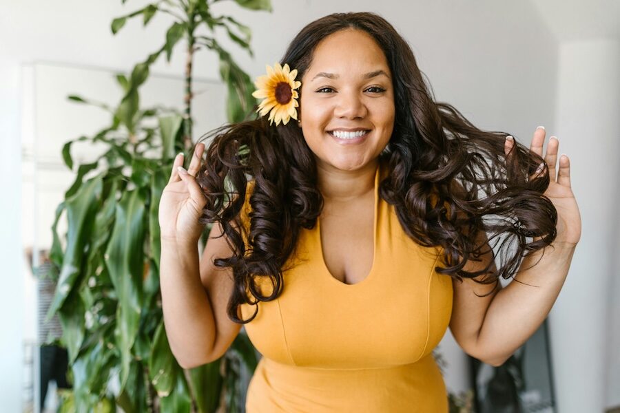 smiling person with sunflower in hair