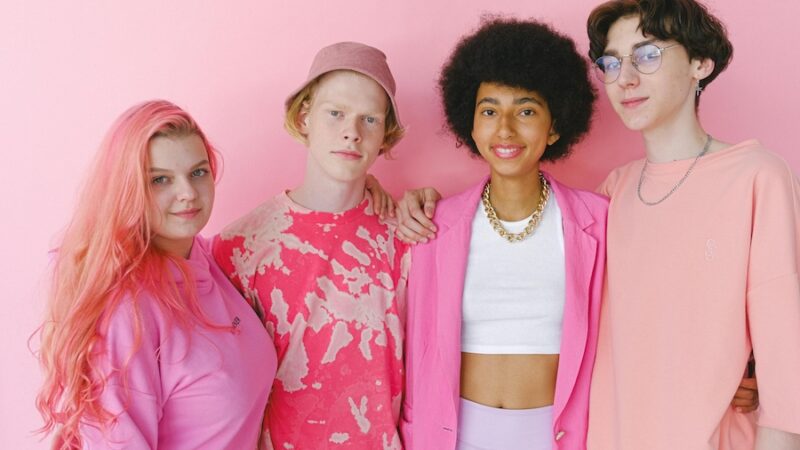 four young people wearing pink