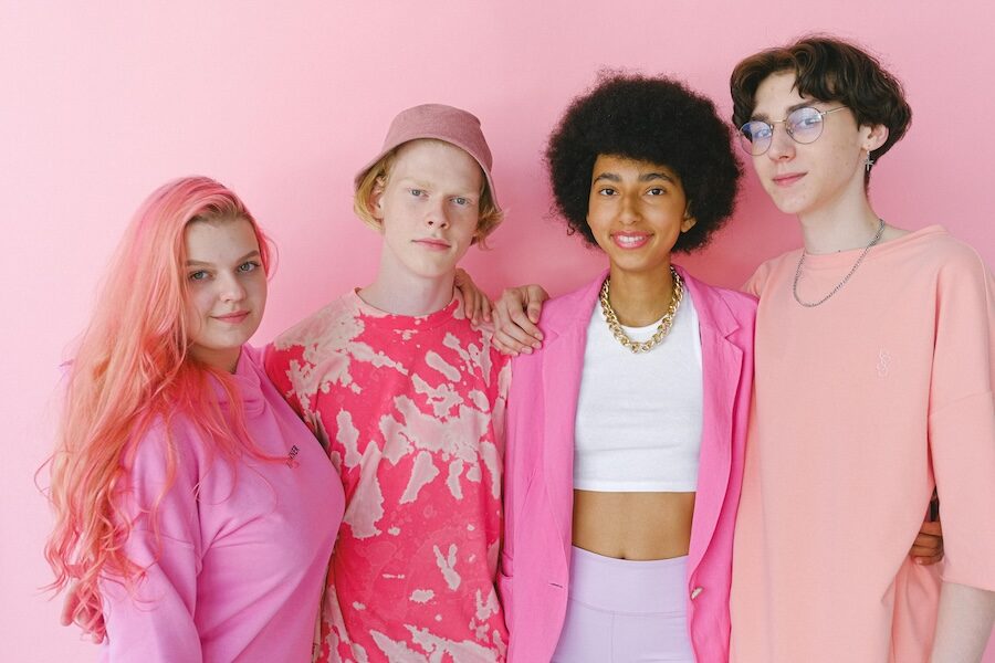 four young people wearing pink