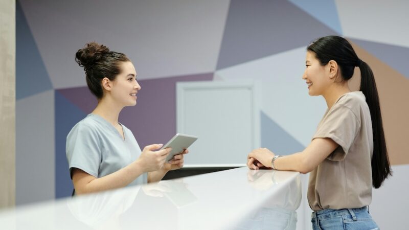 Person talking to receptionist in clinic