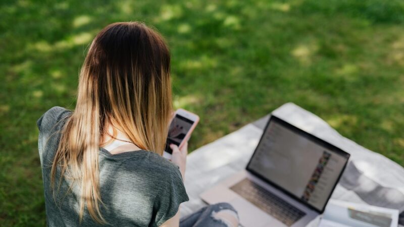 Person on mobile phone and laptop