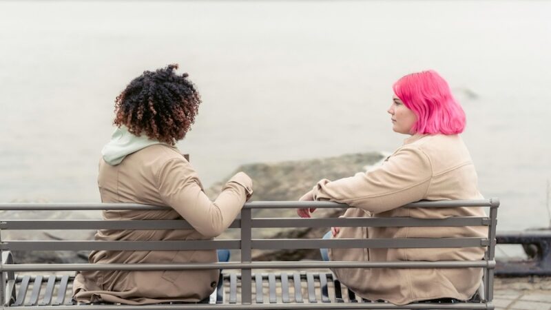 Two people talking on bench