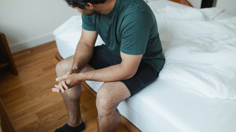 a-man-sitting-on-a-bed-with-his-legs-crossed
