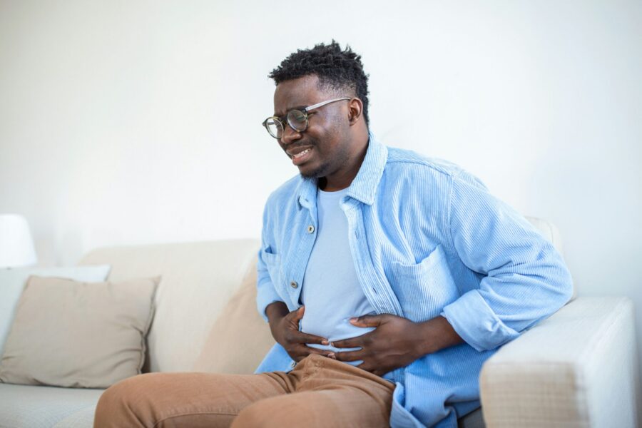 young-african-man-holding-his-stomach-in-pain-man-with-reflux-disease-holding-his-belly-with-painful-expression