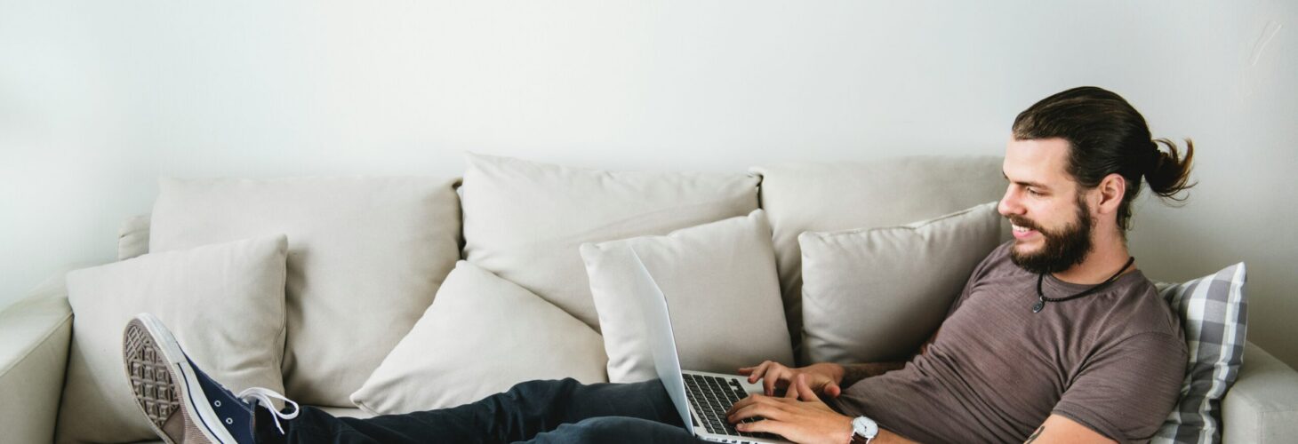 man on laptop sofa home