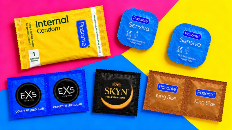 A selection of internal, external and latex-free condom packets arranged on a colourful pink, yellow and blue background.